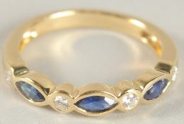 AN 18CT YELLOW GOLD, SAPPHIRE AND DIAMOND HALF HOOP ETERNITY RING.