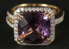 AN 18CT YELLOW GOLD RING set with a large checkerboard cushion-cut amethyst surrounded by RBC