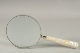 A LARGE MAGNIFYING GLASS with a mother-of-pearl handle.