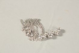 AN 18CT WHITE GOLD AND DIAMOND PENDANT with seven 