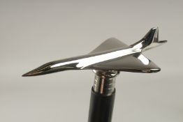 A WOODEN WALKING STICK with CONCORDE HANDLE.