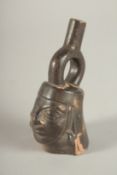 A SMALL TERRACOTTA SOUTH AMERICAN FLASK in the form of a man's head. 9cms high.