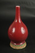 A CHINESE COPPER RED PORCELAIN VASE with stand. Vase: 24cms high.