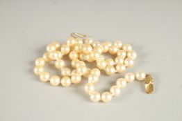 A STRING OF PEARLS, with 9ct gold clasp. 41cms long.