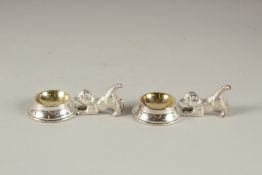 A PAIR OF SILVER-PLATED PUPPY SALTS.