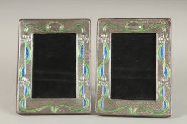 A PAIR OF SILVER AND ENAMEL PHOTOGRAPH FRAMES. 7.5ins x 5.5ins.
