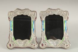 A PAIR OF SILVER AND ENAMEL BUTTERFLY PHOTOGRAPH FRAMES. 8ins x 6ins.