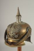 A PRUSSIAN BRASS HELMET stamped JENOKERS, with large metal badge. Eagle F. R. 1813, with spike and