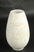 A CHINESE PALE CELADON PORCELAIN DRAGON VASE. 23cms high.