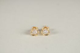 A PAIR OF 18CT YELLOW GOLD AND DIAMOND CLUSTER EAR STUDS.