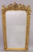 A GOOD LOUIS XVITH STYLE GILTWOOD UPRIGHT MIRROR, carved with cupids and scrolls. 63ins high x 31ins