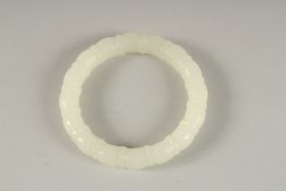 A CARVED WHITE JADE BANGLE. 3ins diameter.