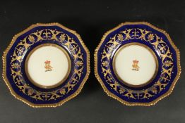 A PAIR OF BLOOR DERBY ARMORIAL CIRCULAR PLATES with rich blue and gilt borders, the centre with a