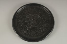 A BOIS DURCI CIRCULAR PLAQUE, depicting classical female figures and putti. 30cms diameter.