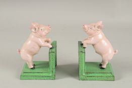 A PAIR OF PAINTED CAST IRON PIG BOOKENDS.