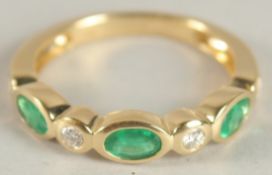 AN 18CT YELLOW GOLD, EMERALD AND DIAMOND HALF HOOP ETERNITY RING.