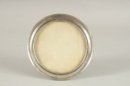 A CIRCULAR SILVER PHOTOGRAPH FRAME. 6ins diameter.