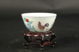 A CHINESE WUCAI CHICKEN TEA CUP on a wooden stand. Cup: 8cms diameter.