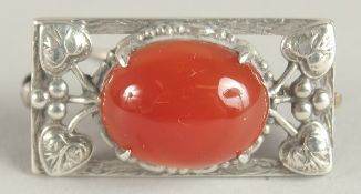 A SMALL SILVER AND CABOCHON BROOCH, in The Manner of Charles Horner. 3cms wide.