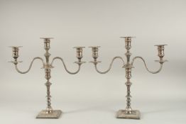 A GOOD PAIR OF SILVER TWO BRANCH CANDLESTICKS on square loaded bases. 14ins high. Sheffield 1922.