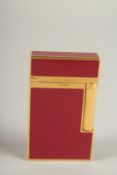 A DUPONT RED ENAMEL AND GILT METAL CIGARETTE LIGHTER.