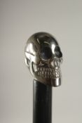 A WOODEN WALKING STICK WITH SKULL HANDLE.