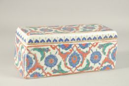 A TURKISH IZNIK GLAZED POTTERY RECTANGLAR LIDDED BOX, 28cm long.