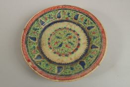 AN EARLY PERSIAN GLAZED POTTERY DISH, painted with foliate designs, 19cm diameter.