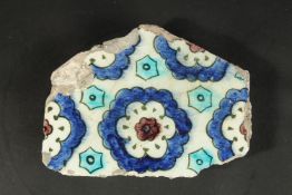 A 16TH CENTURY IZNIK GLAZED POTTERY TILE FRAGMENT, 18.5cm x 14cm.