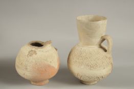 TWO 12TH-13TH CENTURY SELJUK ANAATOLIAN UNGLAZED POTTERY JUGS, one signed, made by Rafi, largest