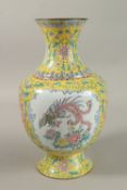 A CHINESE YELLOW GROUND ENAMELLED VASE, painted with a panel depicting an exotic bird and flora,