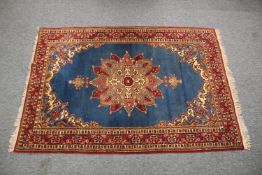 A PERSIAN BLUE GROUND AND RED DESIGN RUG, 180cm x 122cm.