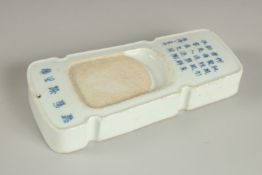 A CHINESE PORCELAIN INKSTONE, with calligraphy inscriptions, 18.5cm long.