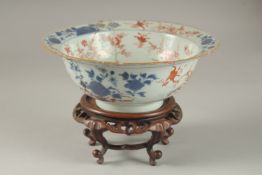 A CHINESE PORCELAIN BOWL AND HARDWOOD STAND, (af), 19cm diameter.