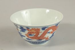 A CHINESE BLUE AND WHITE WITH COPPER RED DRAGON TEA BOWL, six-character mark to base, 11cm