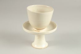 A CHINESE DING WARE CUP AND PEDESTAL SAUCER DISH.