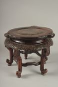 A CHINESE CARVED HARDWOOD STAND, raised on five stretchered legs, the central circular carving