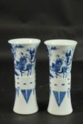 A PAIR OF CHINESE BLUE AND WHITE PORCELAIN GU SHAPE VASES, decorated with figures, 21cm high.