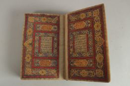 A FINE 19TH CENTURY QAJAR POCKET SIZE QURAN, with original lacquered floral cover and finely