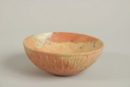 A PERSIAN SIGNED CARVED STONE BOWL, with radiating sun design to the exterior, the base with incised