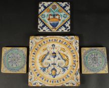 A COLLECTION OF FOUR ITALIAN / EUROPEAN GLAZED POTTERY TILES, largest 20cm square.