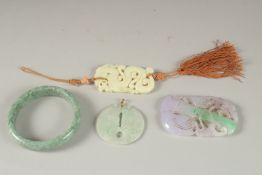 THREE CARVED JADE PENDANTS, one with gold clasp, together with a green hardstone bangle, (4).