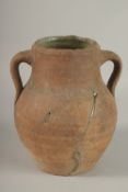 A 10TH CENTURY MIDDLE EASTERN UNGLAZED POTTERY TWIN HANDLE JUG, the interior with traces of green