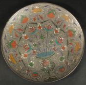 AN INDIAN ENGRAVED AND ENAMELLED WHITE METAL FLORAL DISH, 29cm diameter.