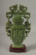 A LARGE CHINESE CARVED GREEN HARDSTONE LIDDED VASE, with twin drop ring handles and carved with