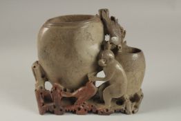 A CHINESE CARVED SOAPSTONE BRUSH POT GROUP, 17cm wide.