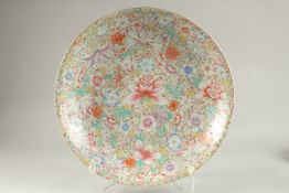 A LARGE CHINESE MILLEFLEUR PORCELAIN CHARGER, the base with character mark in red, 40cm diameter.