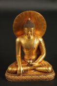 A CHINESE GILT BRONZE SEATED BUDDHA, the reverse inscribed, 16cm high.