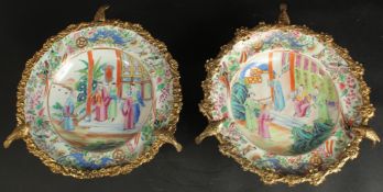 A FINE PAIR OF CHINESE CANTON FAMILLE ROSE PORCELAIN PLATES with gilded metal foliate mounts with