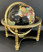 Globe made from polished stone on a brass stand